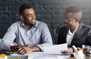 two-confident-successful-dark-skinned-business-partners-having-nice-conversation_273609-9165